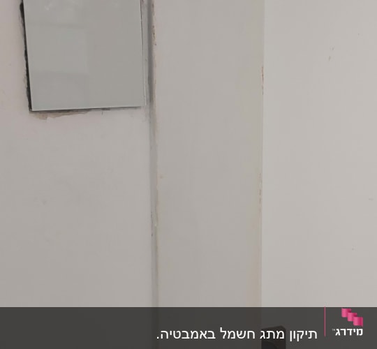 מתג חשמלי על קיר לבן ליד דלת